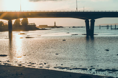 Bridge over river against sky during sunset