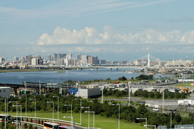 Sea by cityscape against sky