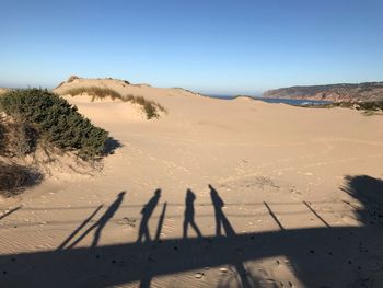 Shadow of people on sand at beach