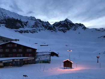 Scenic view of snow covered houses and mountains against sky