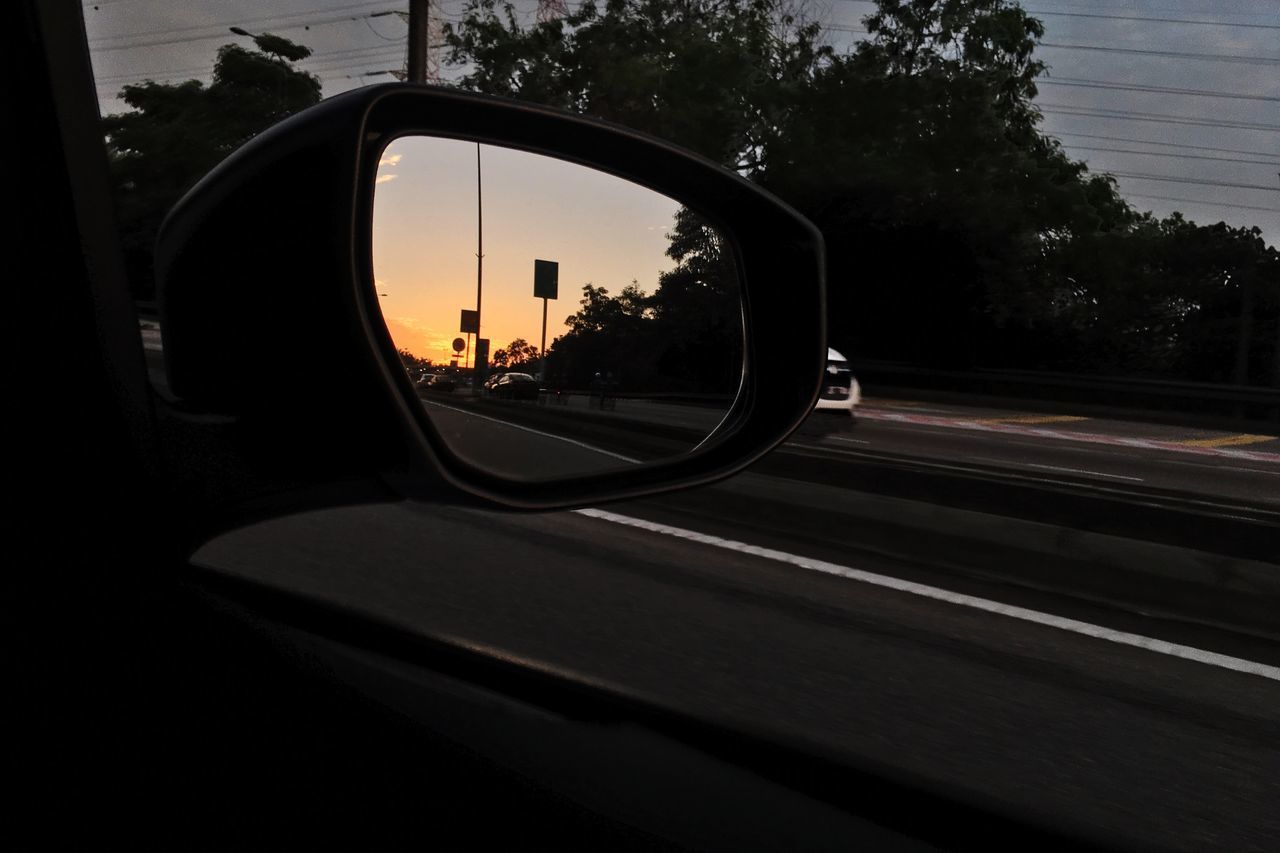 CLOSE-UP OF SIDE-VIEW MIRROR AGAINST SKY