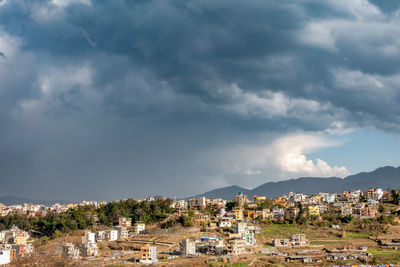 View of townscape against cloudy sky