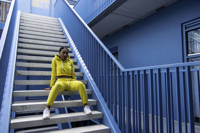 Woman sitting on staircase of building