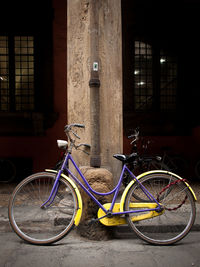 Bicycle parked against wall in city at night