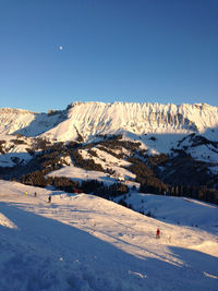 Scenic view of snowcapped mountains against clear blue sky