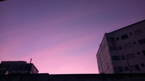 Low angle view of silhouette buildings against sky