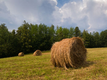 Hay bales on field against sky