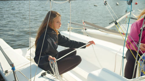 Woman sitting on boat sailing in sea