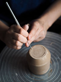 Midsection of woman making earthenware at workshop