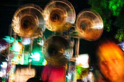 Close-up of illuminated lighting equipment hanging at night