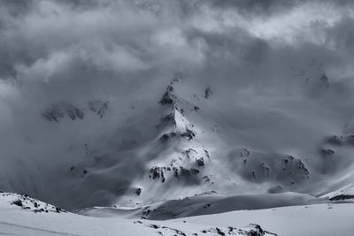 Low angle view of snowcapped mountains against sky