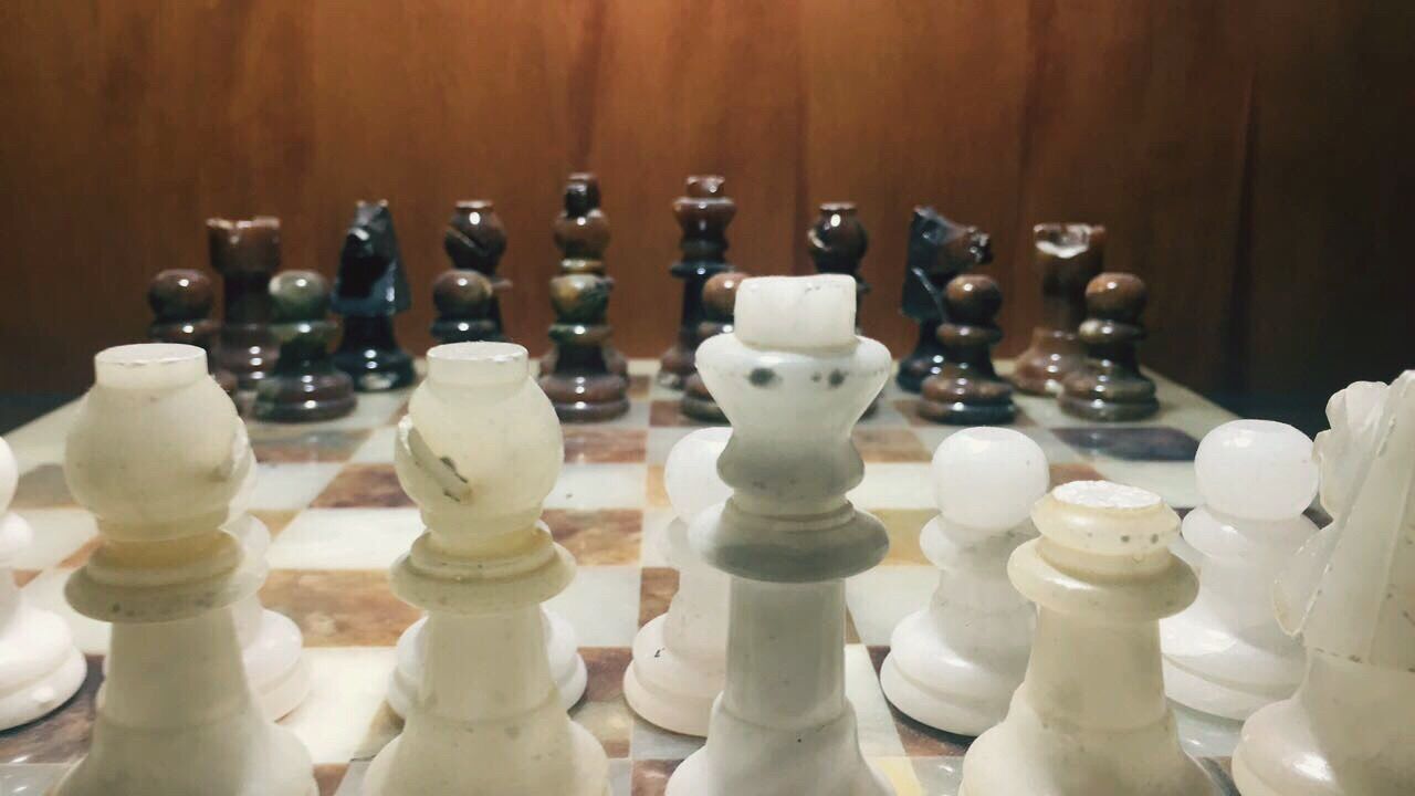 CLOSE-UP OF CHESS PIECES ON BOARD