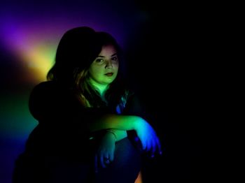 Portrait of a beautiful young woman over black background