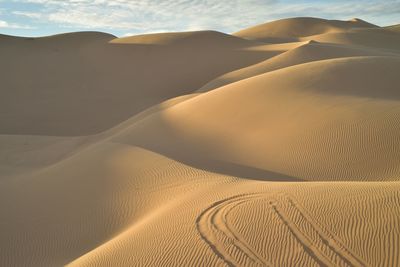 Sand dune in desert against sky