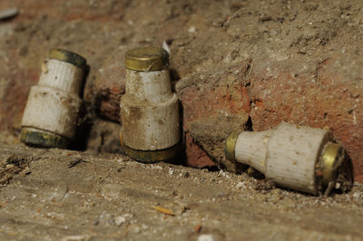 Close-up of old abandoned bottle against wall