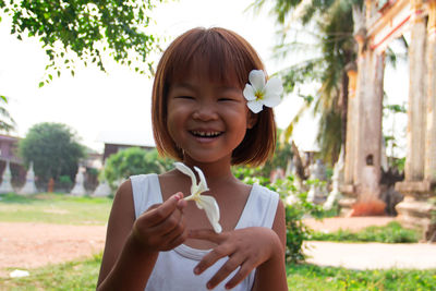 Portrait of smiling girl holding flowers