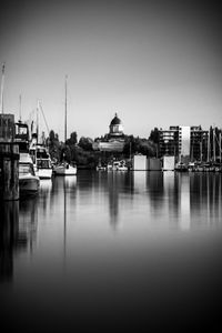 Boats moored in harbor against buildings in city