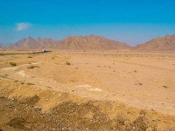 Scenic view of desert against clear blue sky