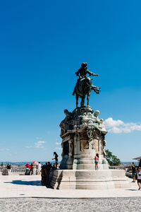 Low angle view of statue against blue sky