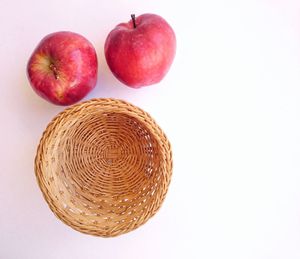 Close-up of apples in basket against white background