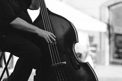 Midsection of man playing guitar outdoors