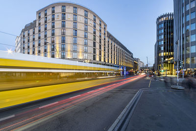 Blurred motion of light trails on road amidst buildings in city