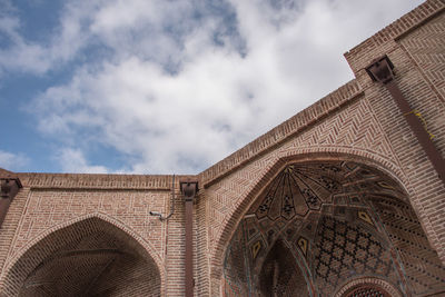 Low angle view of building against cloudy sky