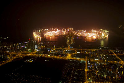 Illuminated cityscape against sky at night