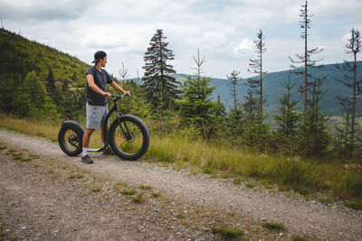 Swarthier type of person rides downhill mountain scooter. dolni morava resort, jeseniky 