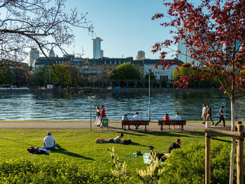 People on lake against buildings