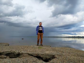 Full length of man standing in sea against sky