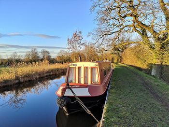 Boat moored on lake against sky