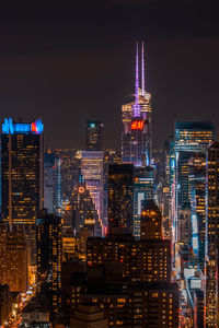 Illuminated buildings in city against sky at night