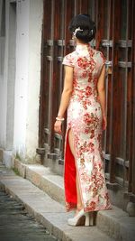 Full length of woman sitting on wall
