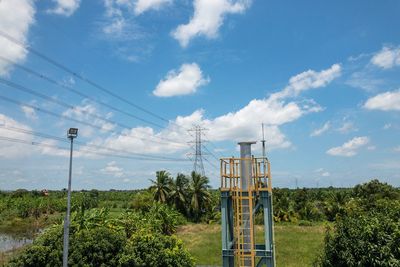 Electricity pylon against cloudy sky