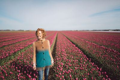 Portrait of woman standing on field against sky