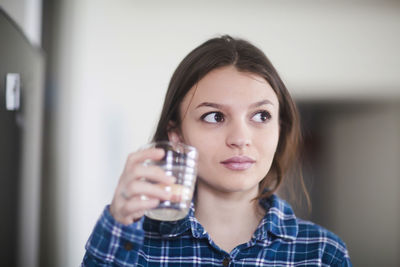 Young woman drinking water at home