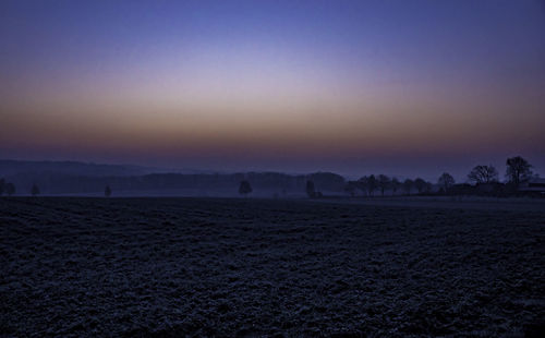 Scenic view of field against sky at sunset