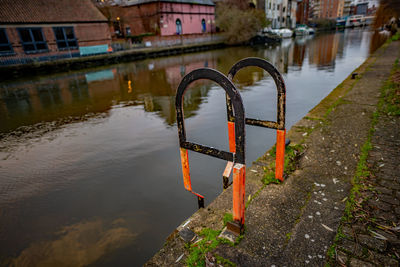 Metallic structure on river by buildings in city