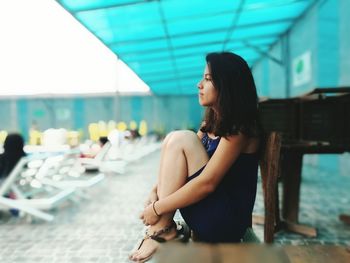 Side view of young woman sitting in sea