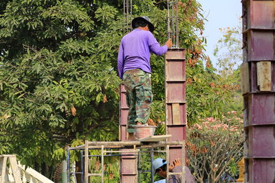 Rear view of man standing by plants