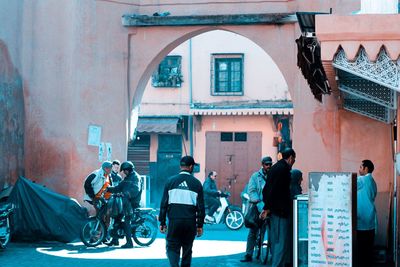 Rear view of people walking on street against buildings