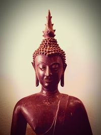 Close-up of buddha statue against wall