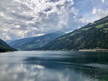 Scenic view of lake by mountains against sky