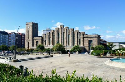 Man walking on pathway against coruna railway station