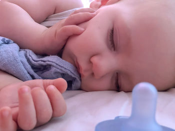 Close-up of baby sleeping on bed