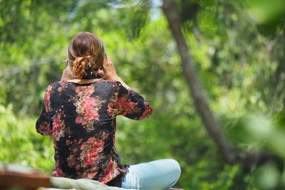 Rear view of woman sitting outdoors