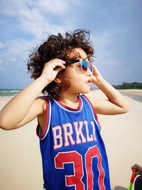 Boy wearing sunglasses while standing at beach