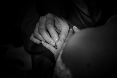 Midsection of bridegroom putting ring on bride during wedding ceremony