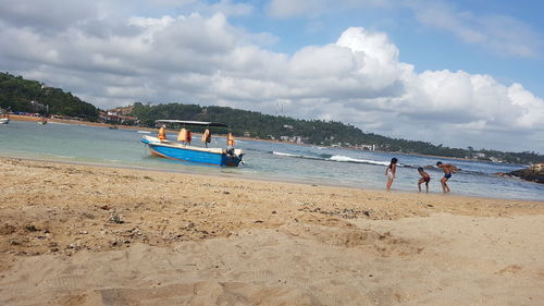 Scenic view of beach against cloudy sky